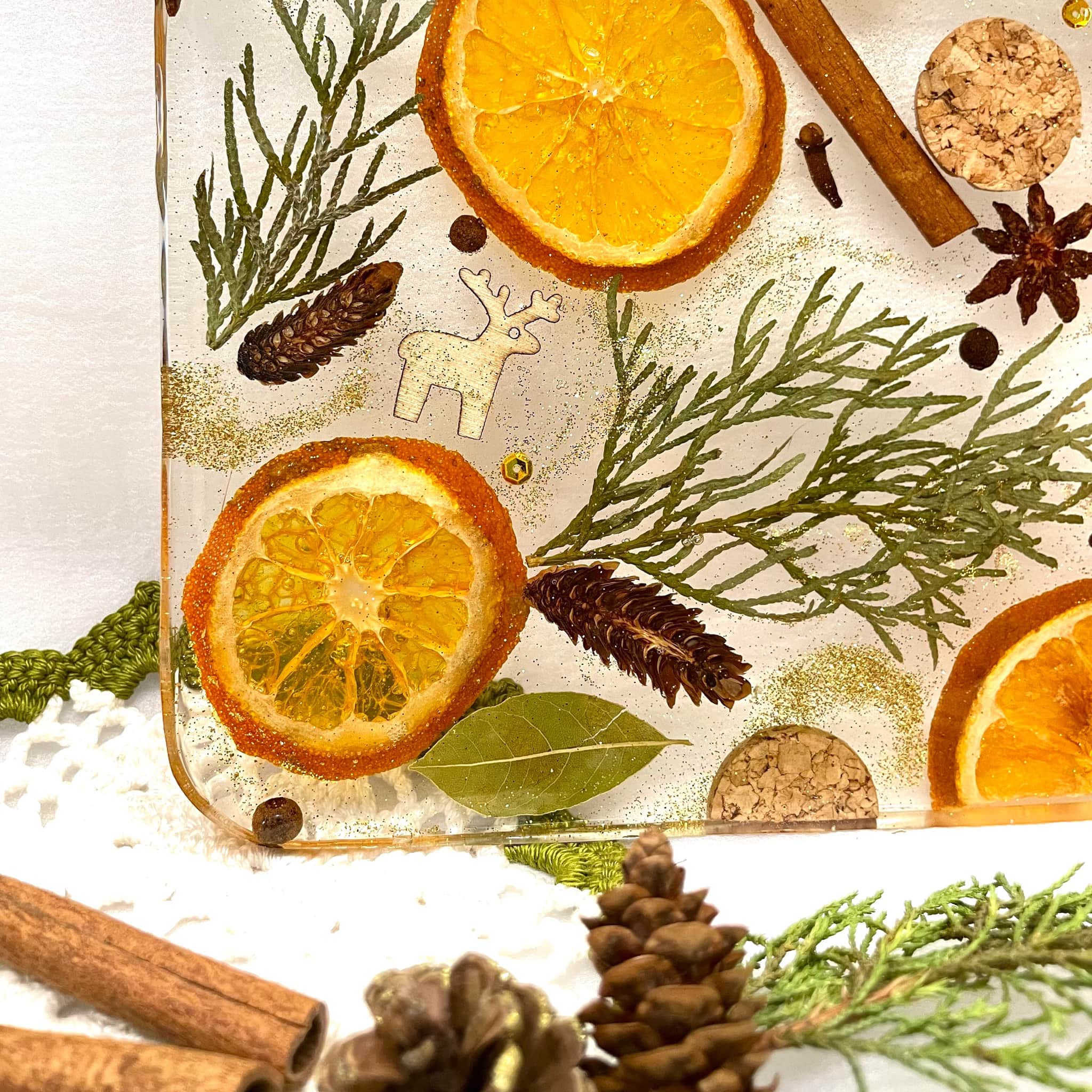 Epoxy resin serving board with orange slices, cinnamon, Christmas elements inside