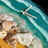 Close-up of beautiful seashore scene on epoxy resin wall clock with natural sand and shells