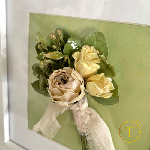 Framed bouquet of flowers with greenery on a light green background