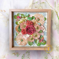 Preserved dried flowers in a shadow box with a lace background