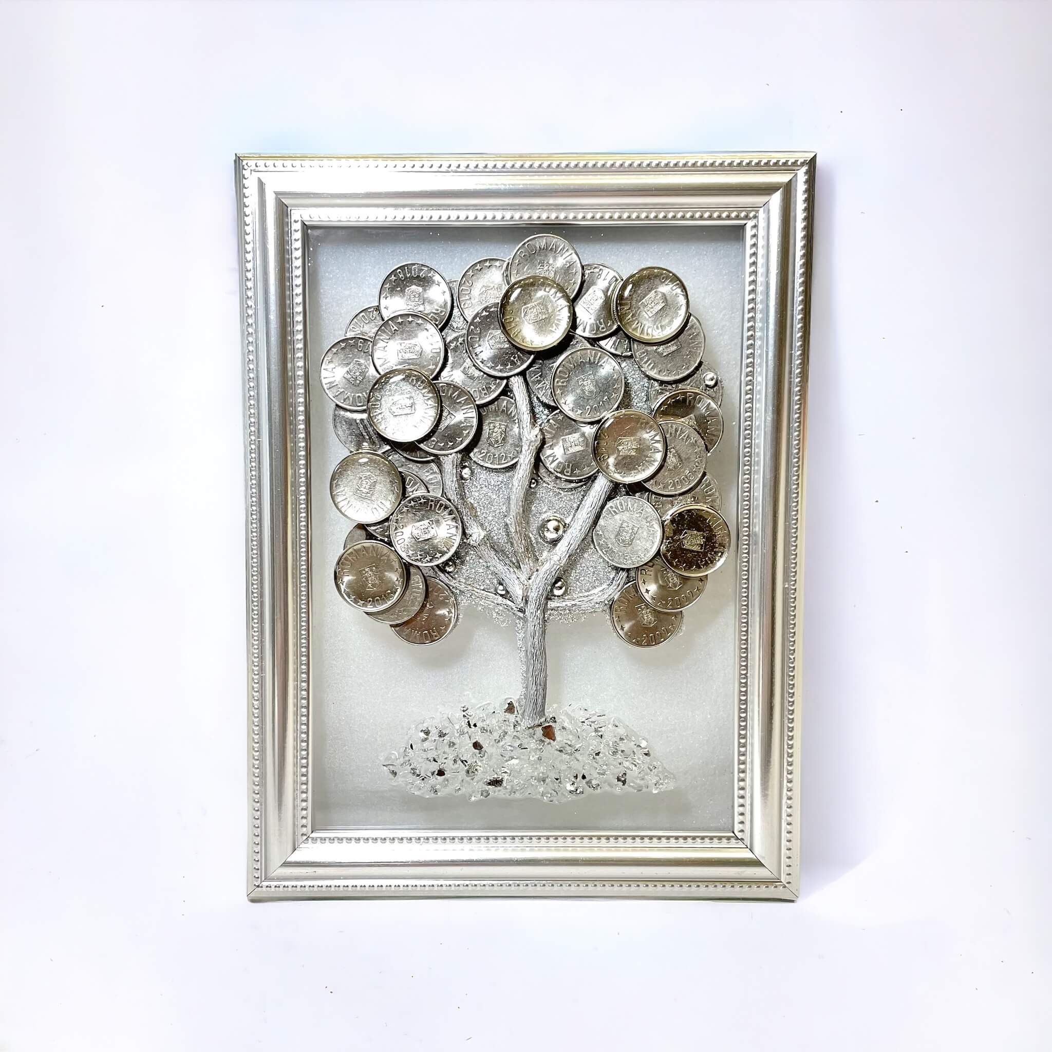 Tree made of coins on framed glass picture