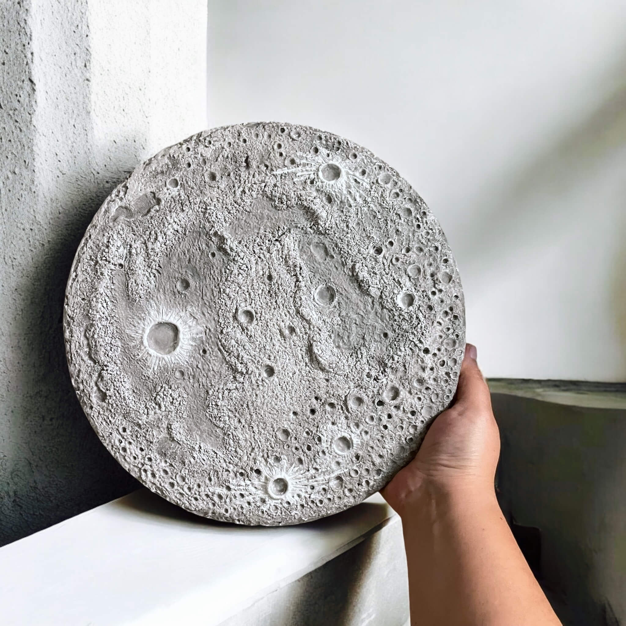 Textured Moon wall art in hands